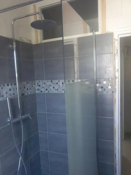 Douche carrelée avec frise en mosaïque et paroi vitrée